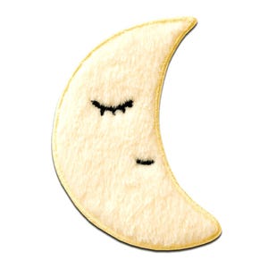 Puede incluir: Un parche de luna creciente de felpa, con una superficie suave de color crema y un borde dorado. La luna presenta ojos negros bordados, lo que le da una expresión de sueño. Ideal para añadir un toque caprichoso a la ropa o accesorios.