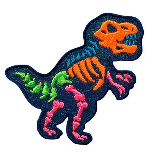Könnte beinhalten: Ein blauer gestickter Bügeleisen-Aufnäher mit einem Dinosaurierskelett mit neonrosa, orangefarbenen und grünen Details.