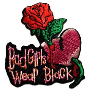 May include: Embroidered patch featuring a red rose and a pink heart with the text "Bad Girls Wear Black" in pink and orange lettering on a black background. The patch has green leaves and stems.