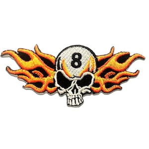 May include: Embroidered patch featuring a white skull with a black eight ball in its eye sockets, surrounded by orange and yellow flames.