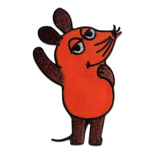 Puede incluir: Un parche bordado naranja de un ratón de dibujos animados con orejas, brazos y piernas marrones. El ratón está de pie con el brazo derecho levantado y el brazo izquierdo doblado en el codo. El ratón tiene una nariz negra y bigotes.