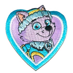 Peut inclure: Un patch brodé thermocollant en forme de cœur. Le cœur est bleu avec un contour blanc. À l'intérieur du cœur se trouve un chat de dessin animé violet portant un chapeau bleu et jaune. Le chat a des yeux bleus et un nez noir.