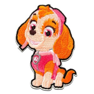 Könnte beinhalten: Gestickter Aufnäher mit einem Cartoon-Hund mit rosa und orangefarbenem Fell, der eine rosa und weiße Uniform mit einem Pfotenabdruck-Abzeichen trägt. Der Hund hat eine rosa Nase, braune Augen und eine rosa Schleife auf dem Kopf.