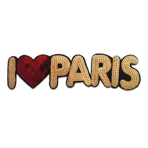Può includere: Una toppa con paillettes con la scritta "I ❤️ PARIS". La "I" e "PARIS" sono dorate, mentre il cuore è rosso. La toppa ha un bordo nero ed è posta su uno sfondo bianco.