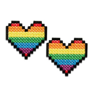Può includere: Due toppe a forma di cuore pixelate con i colori dell'arcobaleno. I cuori sono fatti di un motivo arcobaleno con i colori rosso, arancione, giallo, verde, blu, indaco e viola.