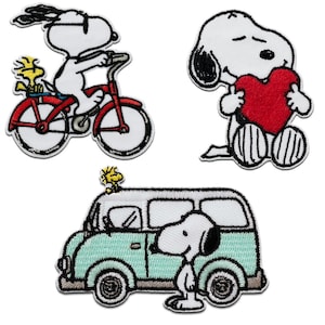 Peut inclure: Trois écussons brodés représentant Snoopy et Woodstock. Un écusson montre Snoopy sur un vélo rouge avec Woodstock à l'arrière. Un autre montre Snoopy tenant un grand cœur rouge. Le troisième montre Snoopy debout près d'un van bleu clair.