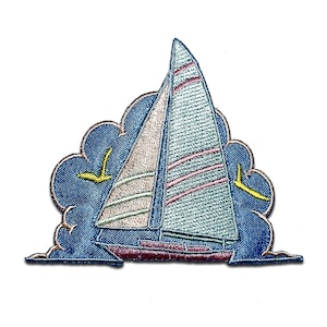 Könnte beinhalten: Ein gestickter Aufnäher mit einem Segelboot mit blauem, rosa und weißem Segel, das auf blauem Hintergrund mit gelben Vögeln, die darüber fliegen, segelt. Der Aufnäher ist von einem blauen, wolkenartigen Rand umgeben.