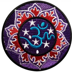 Puede incluir: Parche bordado con un diseño de flor de loto morada, detalles rojos y blancos. El centro presenta un símbolo Om turquesa y estrellas blancas sobre un fondo morado oscuro, con un borde negro. Ideal para ropa o accesorios.