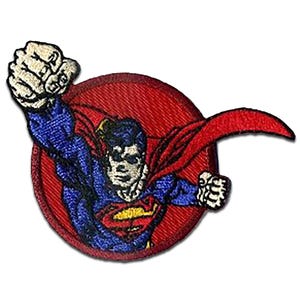 Op de afbeelding: Geborduurde patch met Superman in vlucht. De patch toont Superman in een blauw pak, rode cape en het "S"-embleem op zijn borst, tegen een rode cirkelvormige achtergrond. De patch heeft een diameter van ongeveer 7,6 cm.
