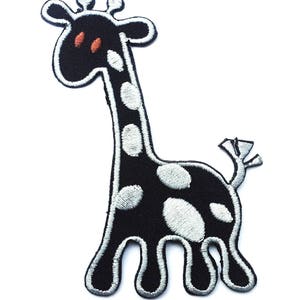 Può includere: Toppa ricamata in bianco e nero da stirare di una giraffa dei cartoni animati con macchie bianche.
