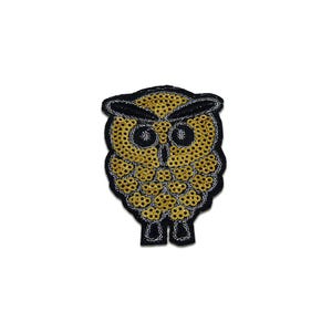 Op de afbeelding: Een uilpatch met gouden pailletten en een zwarte rand. Het lichaam van de uil is gevuld met gouden pailletten en heeft grote, zwarte ogen. De patch is ontworpen om op stof te worden genaaid of gestreken.