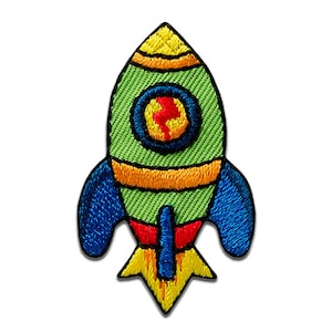 Peut inclure: Écusson de fusée brodée avec un corps vert, des ailettes bleues et des accents jaunes et orange. La fusée présente un design circulaire avec un éclair rouge et jaune. Idéal pour décorer des vêtements ou des accessoires.
