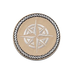 Può includere: Una toppa rotonda beige con un design a rosa dei venti bianca. La rosa dei venti è circondata da un bordo nero e bianco a forma di corda. Adatta per abbigliamento o accessori.