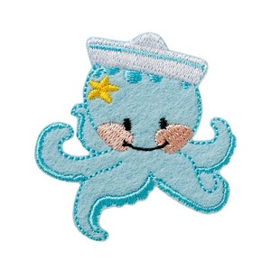 Könnte beinhalten: Ein hellblaues Oktopus-Patch mit Matrosenmütze und gelbem Seestern. Der Oktopus hat ein lächelndes Gesicht mit rosigen Wangen und schwarzen Augen. Der Aufnäher ist aus Filz mit einer gestickten Umrandung.