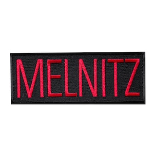 May include: Black rectangular patch with the word "MELNITZ" embroidered in red.