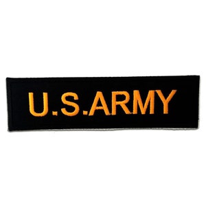 Peut inclure: Un patch rectangulaire noir avec le texte "U.S. ARMY" brodé en orange.