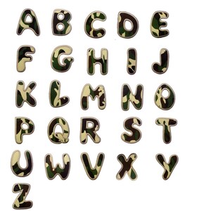 Op de afbeelding: Een complete set opstrijkbare letters van het alfabet. Elke letter heeft een blokstijl met een camouflagepatroon in groen, bruin en beige. De letters hebben een lichtbeige rand en zijn geplaatst op een witte achtergrond.