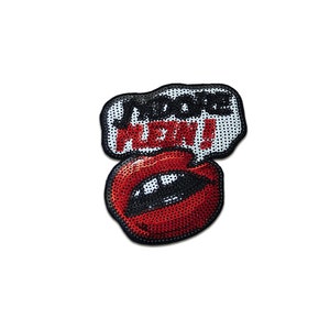 Könnte beinhalten: Ein roter Pailletten-Lippen-Patch mit einer Sprechblase, auf der "WOO HOO! MEOW!" in Schwarzweiß steht.