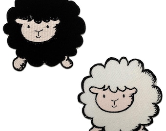Pode incluir: Dois patches de ovelhas bordadas. Um é uma ovelha preta com rosto branco e detalhes rosa. O outro é uma ovelha branca com rosto rosa e detalhes rosa. Ambos os patches têm uma aparência fofa, semelhante a uma nuvem.