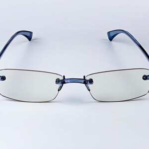 Puede incluir: Un par de gafas azules sin montura con un marco rectangular.