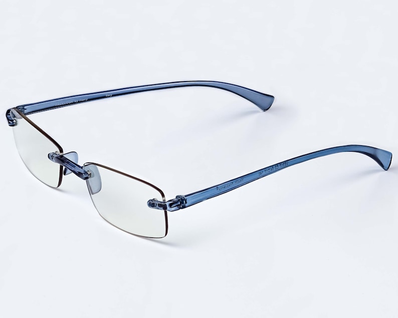 Puede incluir: Gafas de lectura sin montura azules con lentes transparentes. Las gafas tienen una montura flexible y est&aacute;n hechas de pl&aacute;stico.