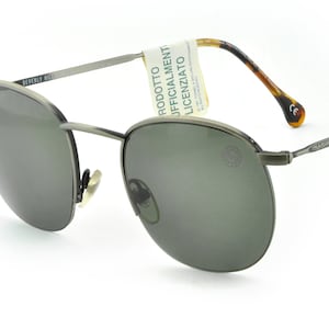 Vintage sunglasses by Dylan Beverly Hills 90210, made in Italy in the 1990s. Round semi-rimless gunmetal frame with UV protected lenses