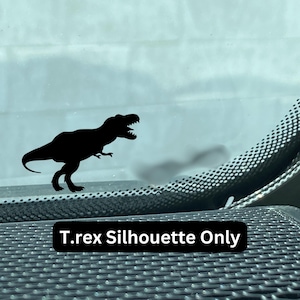 May include: Black silhouette of a Tyrannosaurus Rex dinosaur on a car window. The text "T.rex Silhouette Only" is below the dinosaur.