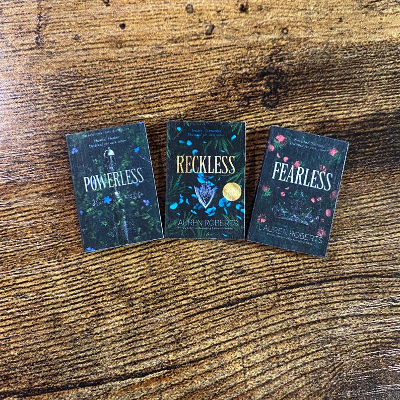 Pode incluir: Tr&ecirc;s livros de bolso com capas pretas e desenhos florais. Os t&iacute;tulos s&atilde;o "Powerless", "Reckless" e "Fearless" de Lauren Roberts.