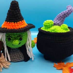 May include: Crocheted Halloween decorations. A green witch with a black and orange hat and a cauldron with green potion. The witch has white hair and a broom. The cauldron is black with a purple tentacle.