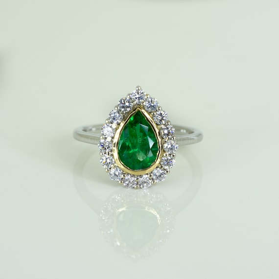 Bezel Set Emerald in a Diamond Halo Ring in 18K Gold