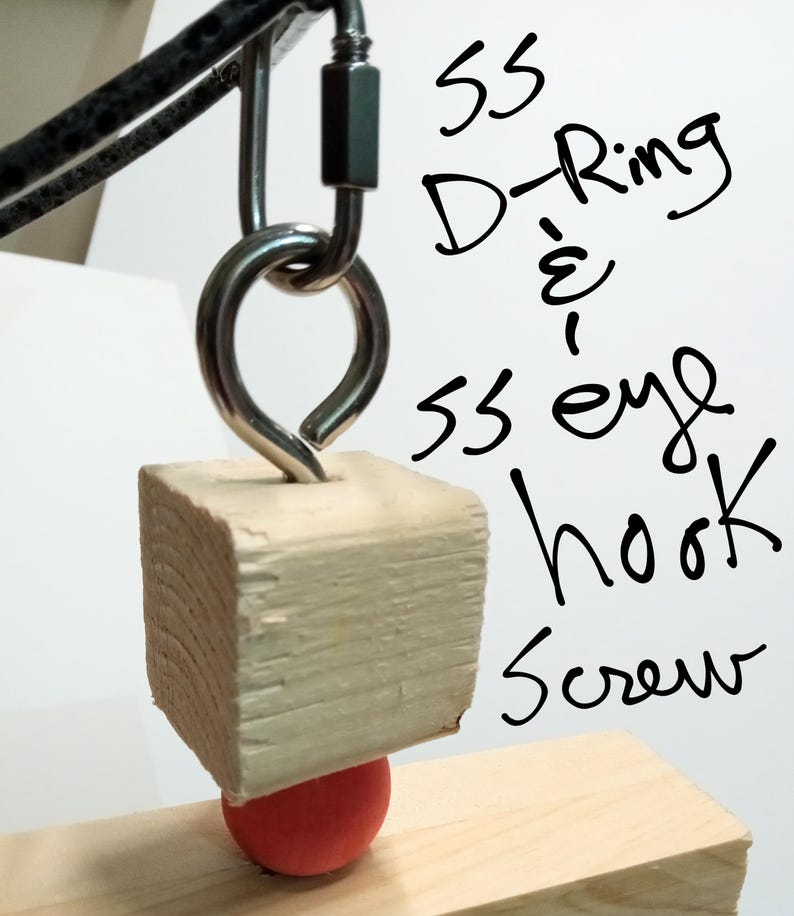 Puede incluir: Primer plano de un bloque de madera con un tornillo de gancho de ojo de metal y una bola roja. El gancho de ojo est&aacute; conectado a una anilla en D de metal y a un mosquet&oacute;n. El texto en la imagen dice "SS D-Ring & SS eye hook Screw."