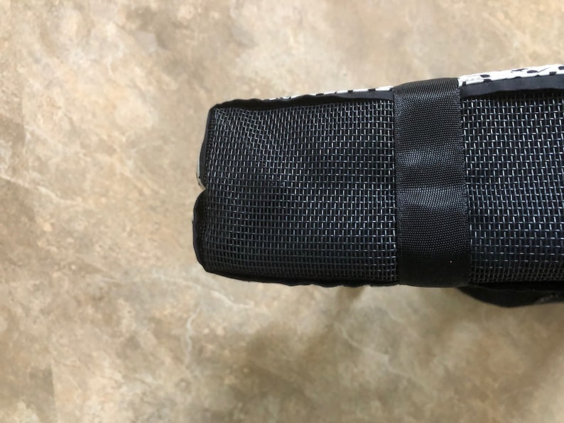 May include: Black and white patterned tote bag with a black mesh panel and a black strap.