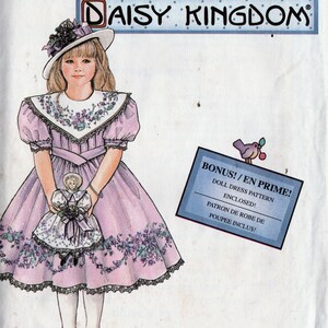 Può includere: Modello di cucito Simplicity per un vestito da bambola di Daisy Kingdom. Il modello presenta una ragazza in un vestito rosa con accenti floreali, che tiene in mano una bambola abbinata. Include un modello di vestito da bambola bonus.