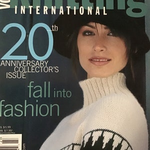 Puede incluir: Portada de la revista Vogue Knitting International con una mujer que lleva un suéter de punto blanco y negro con un sombrero negro. El texto de la portada dice "20º Aniversario Edición de Coleccionista" y "Caer en la moda".