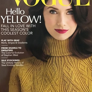 Op de afbeelding: Vogue Knitting magazine cover met een vrouw die een gele gebreide trui met een rolkraag en een getextureerde yoke draagt. De tekst op de cover luidt "Hello Yellow! Verliefd worden op de coolste kleur van dit seizoen."