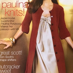 May include: A magazine cover with a woman in a rust-coloured, long cardigan over a light dress. The magazine is "Vogue International" with the headline "paulina knits!" and the text "british invas".