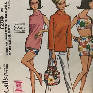 May include: A vintage sewing pattern featuring three women's outfits. The first outfit is a pink sleeveless top with white shorts, the second outfit is an orange long-sleeved top with white trousers, and the third outfit is a floral print crop top with a matching skirt. The pattern is titled "McCall's 1255" and is for misses' and junior separates.