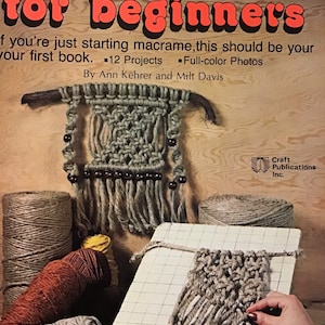 Peut inclure: Une couverture de livre avec le titre "Macramé pour débutants" en lettres rouges et blanches. La couverture présente un fond en bois avec une suspension murale en macramé et une personne travaillant sur un projet de macramé. Le livre comprend 12 projets et des photos en couleur.