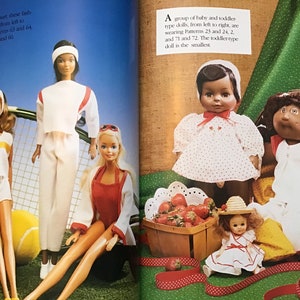 May include: A group of dolls wearing different outfits. The dolls are dressed in white, red, and yellow. The dolls are standing on a green surface with a tennis racket and tennis balls. The text "Dressed for the sport, these bash" is visible in the image.