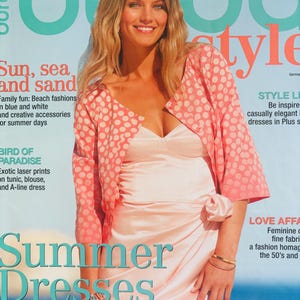 Könnte beinhalten: Ein Magazin-Cover mit einer Frau in einem hellrosa Kleid und einer passenden Jacke mit weißen Punkten. Der Titel lautet "Sommerkleider" und "Sonne, Meer und Sand".