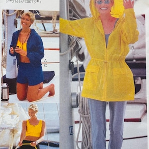 May include: Vogue Patterns sewing pattern 7092, featuring a yellow hooded jacket, blue shorts, and black pants. The pattern includes sizes L-XL. The image shows a woman wearing the clothing on a boat.