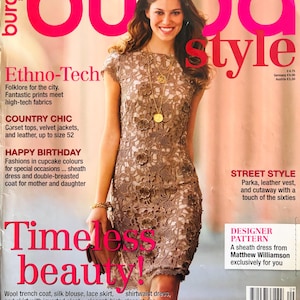 Op de afbeelding: Een tijdschriftomslag met een vrouw in een bruine kanten jurk. De titel "burda style" is roze. Tekst bevat "Ethno-Tech", "Country Chic", "Happy Birthday" en "Timeless beauty!" met modethema's.