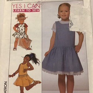 Peut inclure: Patron de couture Simplicity numéro 9271 pour les tailles 6, 7 et 8. Le patron comprend des instructions pour réaliser une robe sans manches avec une jupe plissée. Le patron est intitulé "Yes I Can Learn to Sew".
