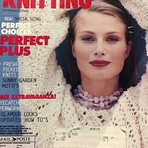 May include: A magazine cover for Vogue Knitting, featuring a woman wearing a white crocheted sweater. The cover text reads "Perfect Choice, Perfect Plus" and "Fresh Picked Knits, Sunny Garden Motifs".