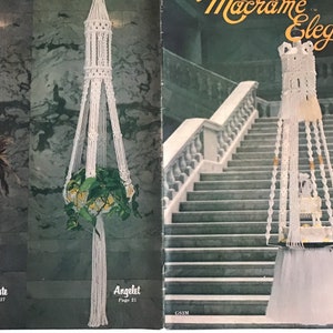May include: A book titled "Macrame Elegance III" featuring a white macrame plant hanger on the cover. The hanger is suspended from a staircase bannister. The book cover also displays two other macrame plant hangers.