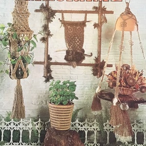 May include: A book cover with the title "mad about, MACRAME" and a picture of macrame plant hangers, a macrame owl wall hanging, and a macrame hanging shelf. The text "INCLUDES POT HANGERS - JEWELRY - WALL HANGINGS & HOME ACCESSORIES" is at the bottom of the cover.