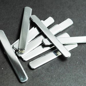 May include: A pile of silver metal strips, likely used for crafts or jewelry making.