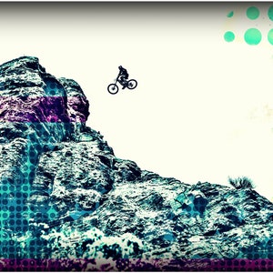May include: A silhouette of a person riding a mountain bike over a rocky cliff. The background is a white sky with a blue and green polka dot pattern.