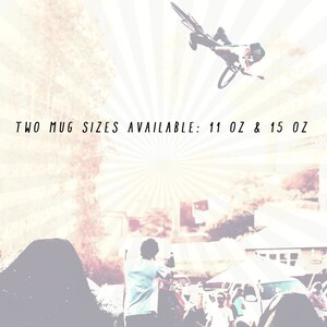 May include: Two mug sizes available: 11 oz & 15 oz. A vintage-style image with a cyclist performing a trick on a dirt bike ramp. The image has a faded, sun-bleached effect.