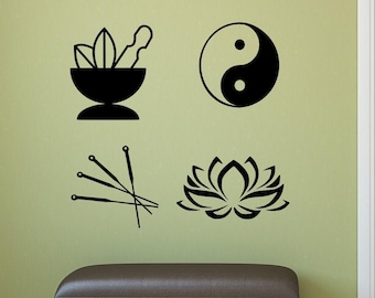 May include: A set of four black wall decals featuring a mortar and pestle with leaves, a yin-yang symbol, a cluster of four acupuncture needles, and a stylised lotus flower. These graphic icons are arranged in a grid pattern on a light green wall.